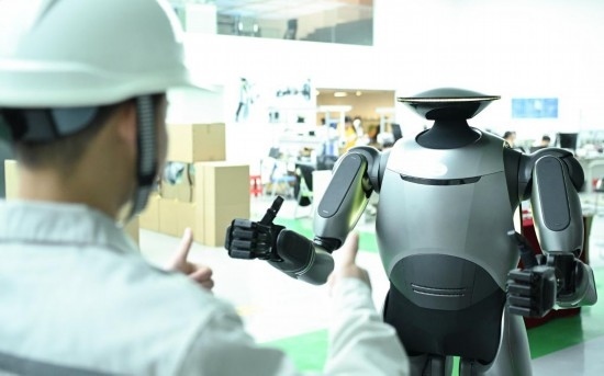 在廣汽研究院，人形機(jī)器人團(tuán)隊的周仁義在演示GoMate機(jī)器人互動功能（新華社記者 鄧華 攝）