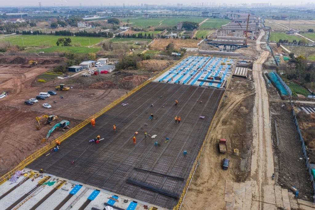 3月7日，在524國道秀洲王江涇至新塍公路工程TJ02標(biāo)段，作業(yè)人員正在進(jìn)行60米鋼混組合梁現(xiàn)澆橋面板鋼筋焊接及綁扎作業(yè)（無人機(jī)照片）。新華社記者 徐昱 攝