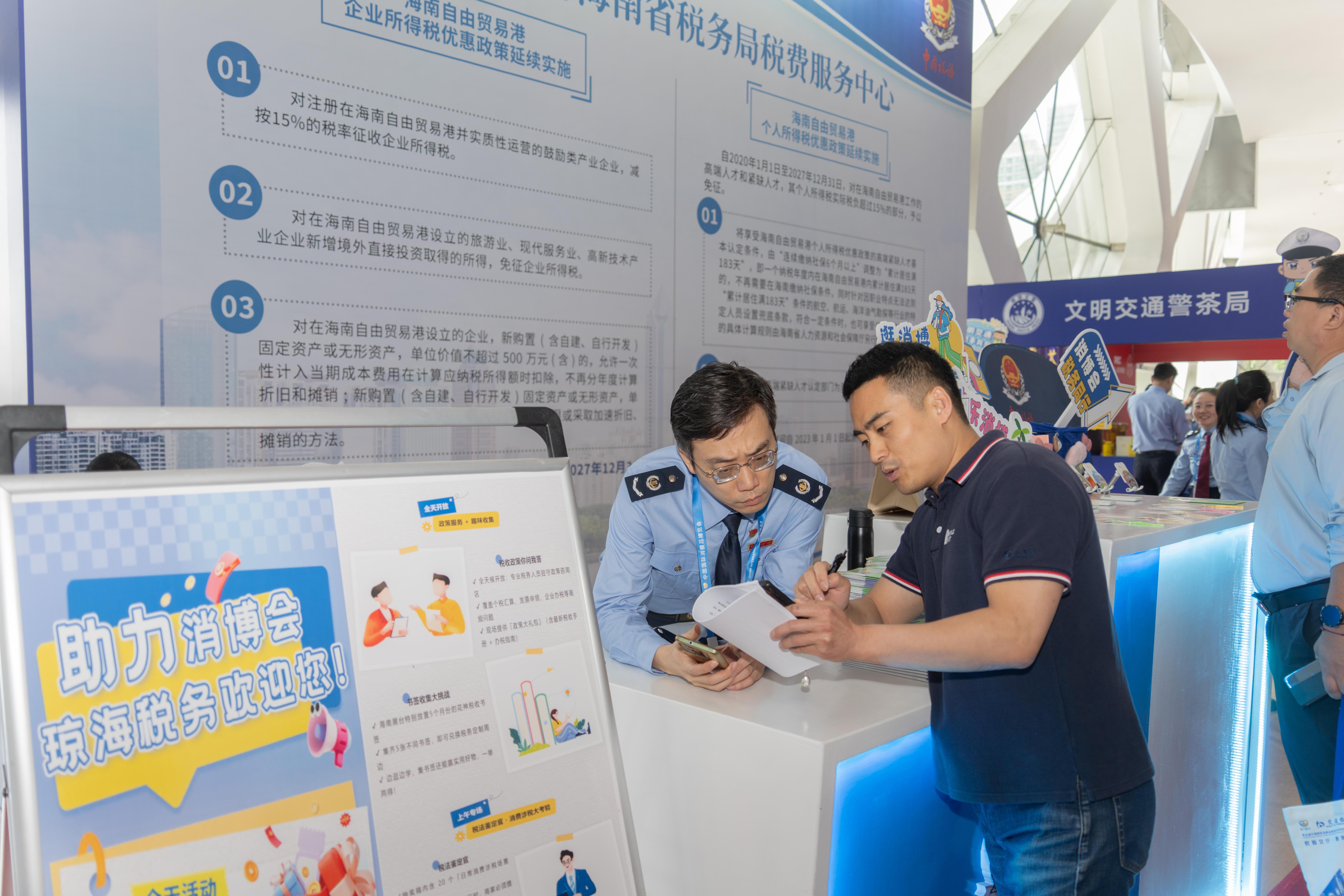 稅務服務臺工作人員向記者介紹服務參展外商的具體舉措。人民網(wǎng)記者 許崢攝