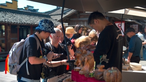 “五一”期間，游客正在烏鎮(zhèn)“水鄉(xiāng)碼頭”挑選購(gòu)買文創(chuàng)產(chǎn)品。受訪者供圖