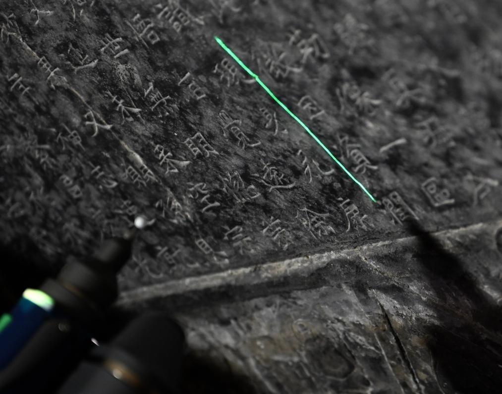 2025年4月9日，龍門(mén)石窟研究院工作人員在古陽(yáng)洞使用關(guān)節(jié)臂掃描儀對(duì)《龍門(mén)二十品》之一進(jìn)行數(shù)字化掃描。新華社記者 李嘉南 攝