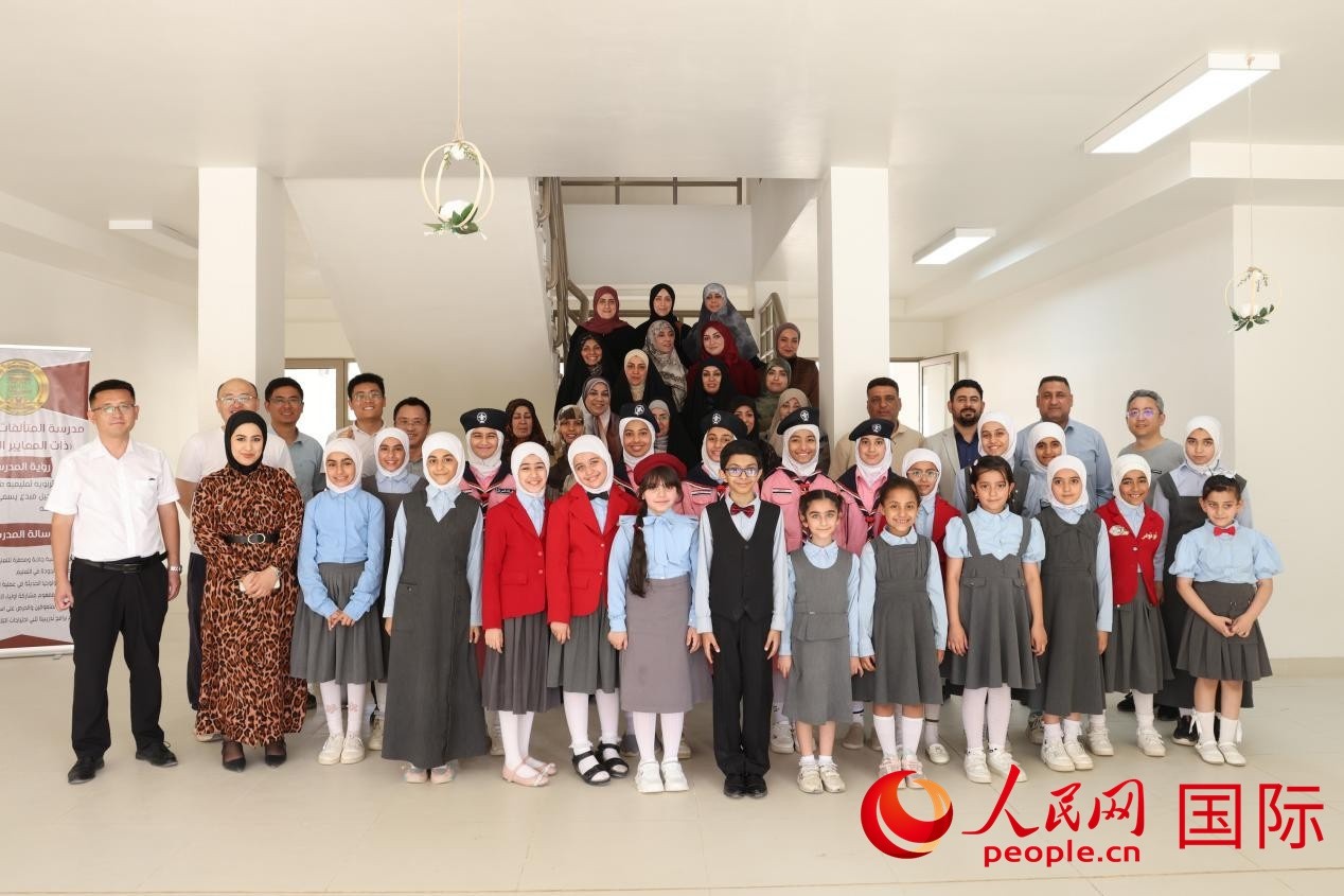 中國電建員工與阿爾穆塔?阿里卡特國際學(xué)校的師生及政府官員等合影。人民網(wǎng)記者 薛丹攝