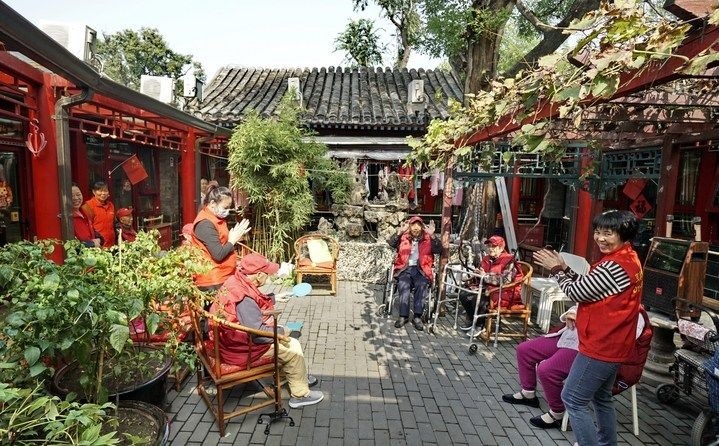 2024年10月12日，鐘樓灣胡同的老年人在社區(qū)內(nèi)的四合院養(yǎng)老驛站休閑。2017年起，北京市先后開展了兩輪背街小巷環(huán)境整治提升行動(dòng)，完整保留了中軸線生活建筑群的歷史信息，并根據(jù)居民的生活和居住方式進(jìn)行適配化的更新和改造，極大地改善了生活環(huán)境。2023年鐘樓灣胡同被評(píng)為“北京最美街巷”。