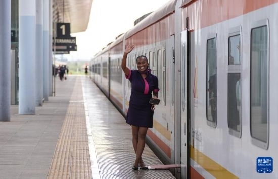 5月31日，在蒙內(nèi)鐵路內(nèi)羅畢站，一名乘務(wù)員在即將開(kāi)往蒙巴薩的E2次列車(chē)旁等候乘客。新華社記者 李亞輝 攝