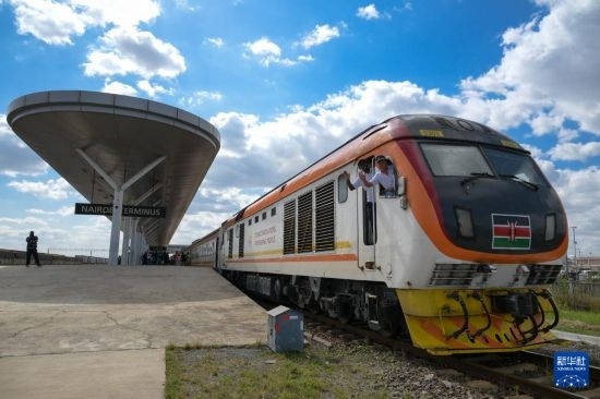 5月31日，在蒙內(nèi)鐵路內(nèi)羅畢站，機(jī)車(chē)駕駛員蔣立平（右）和博爾在即將開(kāi)往蒙巴薩的E2次列車(chē)上揮手致意。新華社記者 楊光 攝